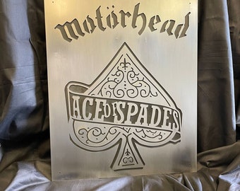 May include: A metal sign with the band name "Motorhead" and the words "Ace of Spades" in a stylized font. The sign features a large, ornate spade design.