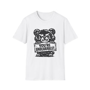 May include: White t-shirt with a black and white illustration of an angry bear holding a sign that reads "YOU'RE UNBEARABLE!". The bear has a fierce expression.