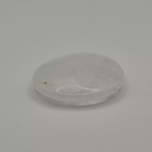 Peut inclure: Une pierre de cristal transparente, lisse et de forme ovale. La pierre a un aspect légèrement translucide et une surface polie. Le cristal est posé sur un fond blanc, ce qui met en valeur sa forme et sa texture naturelles. Idéal pour la méditation et la guérison.