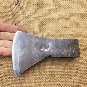 Op de afbeelding: Een vintage, enkelbladige bijl met een stalen kop en een houten steel. De bijlkop heeft een gebogen blad en een afgeronde hamer. De bijl is gemarkeerd met "800" op de kop.