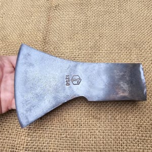 Könnte beinhalten: Ein silberner Axtkopf mit einem sechseckigen Stempel, auf dem "1250" steht.
