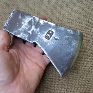 Op de afbeelding: Een vintage bijlkop met een versleten, grijze metalen afwerking. De kop heeft een kleine rechthoekige stempel met de letters "D.D." en het nummer "4" zichtbaar.