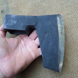 以下が含まれることがあります： 木製の柄が付いた黒い金属製の斧。斧の頭には「IREA」と刻印された小さなロゴがあります。