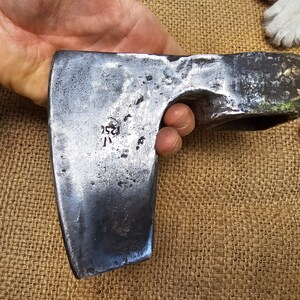 Op de afbeelding: Een vintage handgesmede bijl met een stalen kop en een houten steel. De bijlkop heeft een '1252' markering.