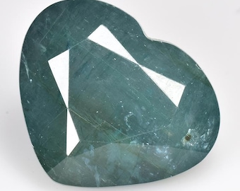 May include: A heart-shaped green gemstone with a faceted cut. The gemstone has a light blue hue and is translucent.