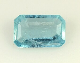 May include: A light blue aquamarine gemstone with a rectangular emerald cut.