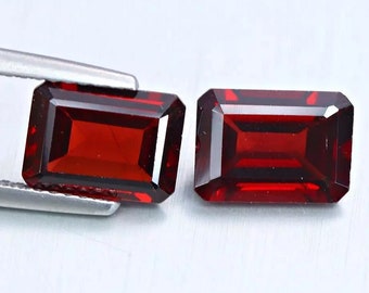 May include: Two rectangular red gemstones with a faceted cut. The gemstones are set in a silver tone setting.