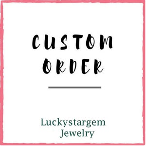 May include: A pink square with a white background and black text that reads "CUSTOM ORDER" with a line underneath. Below the line is the text "Luckystargem Jewelry" in green.