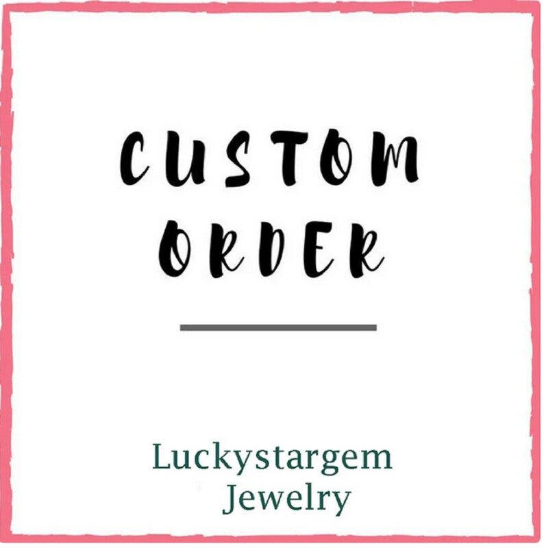 May include: A pink square with a white background and black text that reads "CUSTOM ORDER" with a line underneath. Below the line is the text "Luckystargem Jewelry" in green.
