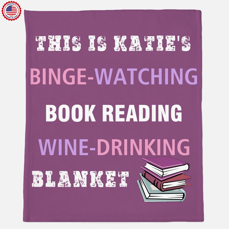 May include: Purple blanket with the text "This is Katie's Binge-Watching Book Reading Wine-Drinking Blanket" in white. A stack of three books is shown in the bottom right corner.