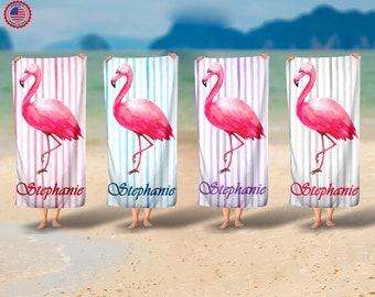 Op de afbeelding: Vier roze flamingo strandhanddoeken met witte strepen en de naam "Stephanie" gedrukt op elke handdoek.