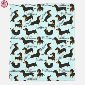 Puede incluir: Un fondo azul claro con un patr&oacute;n repetido de perros salchicha negros y tostados. Cada perro tiene el nombre "William" escrito debajo.