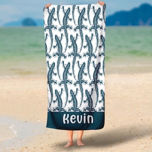 May include: A white beach towel with a blue lizard pattern and the name "Kevin" printed in blue at the bottom.