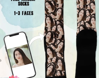 May include: Custom face mashup socks with a repeating pattern of a woman's face. The socks are black at the top and bottom, with the face pattern covering the middle section. The image also shows a smartphone displaying the same face.