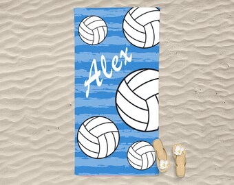 以下が含まれることがあります： 白いバレーボール柄と「Alex」という名前が白で書かれた青いビーチタオル。