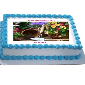 May include: A square white cake with blue frosting and a printed image of a gardening scene with flowers, a trowel, and a pot. The text "Your Message Here" and "or Blank" is printed on the cake.