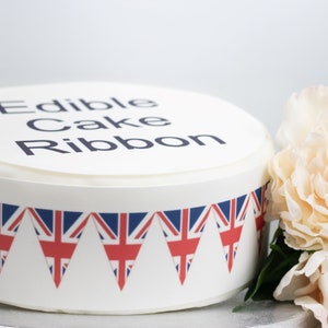 May include: Edible cake ribbon with a Union Jack bunting design. The ribbon says "Edible Cake Ribbon".