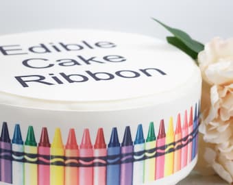 May include: Edible cake ribbon with the text "Edible Cake Ribbon" printed on the top and a row of colorful crayons printed on the bottom.