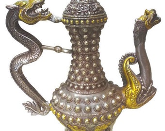 May include: A silver and gold teapot with a dragon handle and a bird spout. The teapot is decorated with intricate details and has a domed lid.