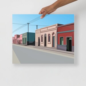 May include: A digital illustration of a street scene with a row of colorful buildings. The buildings have flat roofs and are painted in shades of pink, green, and red. The street is paved and there are power lines overhead.