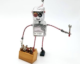 Silver robot figurine with a toolbox, robot assemblage sculpture