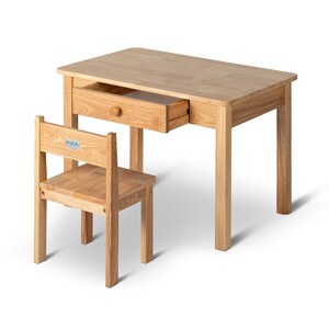 May include: A light-coloured wooden desk with a matching chair. The desk has a single drawer with a round wooden knob. The chair has a rectangular seat and back. The desk and chair are made of light-coloured wood.