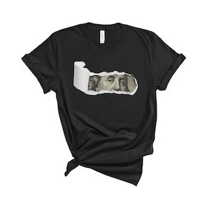 May include: Black t-shirt with a ripped hole revealing a close-up of Benjamin Franklin's face from a US dollar bill.