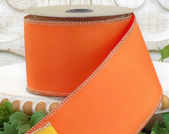 May include: A spool of orange and yellow wired ribbon with gold trim. The ribbon is 2.5 inches wide and has a satin finish.