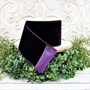 A 4" roll of dark purple velvet sits on a white wood pedestal surrounded by greenery.