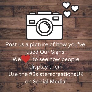 May include: A graphic with a white camera icon, three white hearts, and text on a wooden background. The text reads: "Post us a picture of how you've used Our Signs. We ❤️ to see how people display them. Use the #3sisterscreationsUK on Social Media."