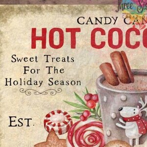 May include: A vintage-style sign with the words "HOT COCOA" in red. The sign features a cup of hot cocoa with cinnamon sticks, a peppermint candy, and a reindeer character. Text reads "Sweet Treats For The Holiday Season."