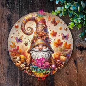 May include: A whimsical fall gnome with a swirling hat adorned with autumn leaves and glitter. The gnome is surrounded by fall foliage, acorns, and pumpkins. The background is a warm, golden color.
