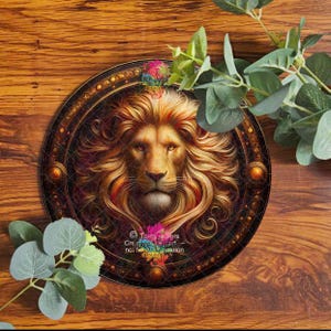 Pode incluir: Imagem circular de um leão majestoso com uma juba dourada detalhada, emoldurada em um círculo adornado com motivos dourados e marrons. O leão é retratado com uma expressão régia. O fundo é de madeira, com folhas verdes.