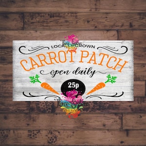 Könnte beinhalten: Ein weißes Holzschild mit schwarzem Text, der "Carrot Patch open daily 25p" lautet. Das Schild hat einen schwarzen Kreis mit weißem Text, der "25p" lautet. Auf beiden Seiten des Kreises befinden sich zwei orangefarbene Karotten mit grünen Blättern. Das Schild hat einen weißen Hintergrund mit Holzmaserung.