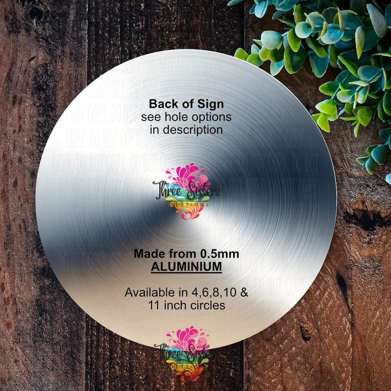 K&ouml;nnte beinhalten: Die R&uuml;ckseite eines silbernen Metallschildes mit der Aufschrift "Back of Sign see hole options in description Three Sisters Creations Made from 0.5mm ALUMINIUM Available in 4, 6, 8, 10 & 11 inch circles".