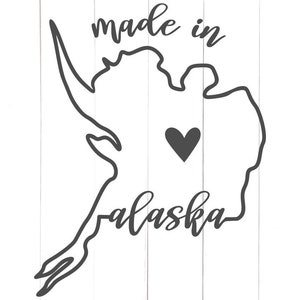 Może przedstawiać: Czarno-biały zarys stanu Alaska z tekstem "made in Alaska" i sercem w środku.