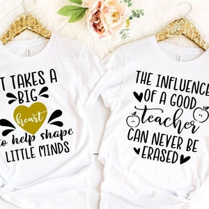 Peut inclure: Deux t-shirts blancs avec du texte noir. Le premier t-shirt dit "Il faut un grand c&oelig;ur pour aider &agrave; fa&ccedil;onner les petits esprits". Le deuxi&egrave;me t-shirt dit "L'influence d'un bon professeur ne peut jamais &ecirc;tre effac&eacute;e".