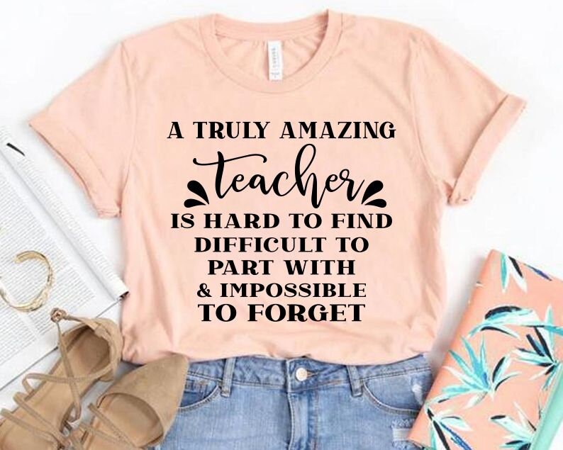 Peut inclure: Un t-shirt rose avec un motif noir qui dit "Un professeur vraiment incroyable est difficile &agrave; trouver, difficile &agrave; quitter et impossible &agrave; oublier."