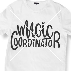 Könnte beinhalten: Weißes T-Shirt mit schwarzem Text, der "Magic Coordinator" lautet, mit einem kleinen Mickey-Maus-Symbol im Text.