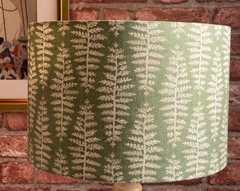 Pantalla de lámpara de lino verde salvia con helechos blancos y grises.
