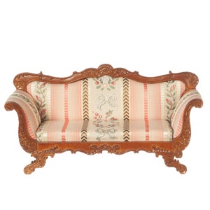 May include: A vintage-style, wooden sofa with a carved frame and floral patterned upholstery. The sofa has a light pink, cream, and green color scheme.