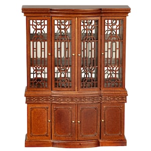 May include: A miniature wooden cabinet with a dark brown finish. The upper section features four glass doors with intricate lattice designs. The lower section has four solid doors. The cabinet has a curved base and decorative carvings.