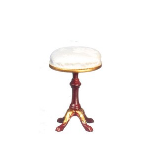 May include: A white upholstered stool with a gold trim around the top. The stool has a red wooden base with gold accents and three legs.