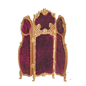 May include: A three-panel room divider with a gold frame and burgundy velvet panels. The divider has a decorative design on the top and bottom of the frame.