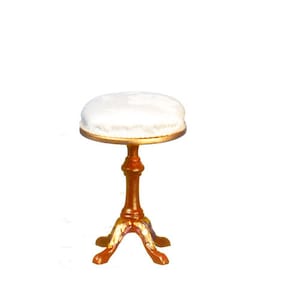 May include: A white upholstered stool with a wooden base. The base has three legs and a gold trim around the top.