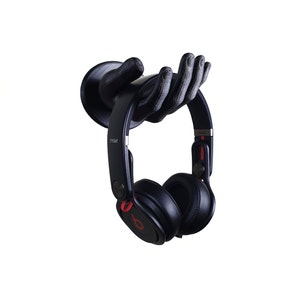 May include: Black headphones with red accents hanging on a 3D printed hand-shaped headphone holder. The headphones have the word "mixr" printed on the side.