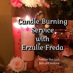 May include: Pink and white candles with a pink heart charm, a glass of red wine, and a figurine of a woman. The candles are labelled "Candle Burning Service with Erzulie Freda" and "Solitaire Bon Lavi BonLaviCreations".