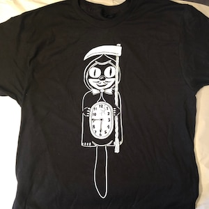 May include: Black t-shirt with a white graphic of a cat wearing a hooded robe and holding a scythe. The cat is also a clock with Roman numerals.
