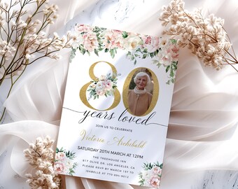 Puede incluir: Una invitación para celebrar 80 años de vida. La invitación presenta un número 80 dorado con flores rosas y blancas, una foto de una mujer y el texto "years loved". La invitación es para Victoria Archibald y está programada para el sábado 20 de marzo a las 12:00 pm en The Treehouse Inn.