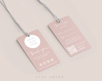 May include: Pink thank you tag with a white circle for a logo, the text "YOUR LOGO HERE" and the words "Thank you" in script. The tag also includes social media icons and the text "FOR YOUR PURCHASE AND SUPPORT" and "FOLLOW US @YOURBUSINESS". The bottom of the tag says "LUXE AMORE". A second pink tag with the text "Olise & Shop BOUTIQUE" and a QR code is also shown.